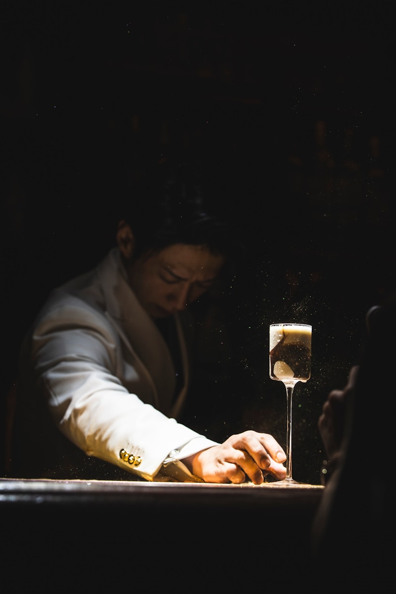 Man in white suit reaching for a drink